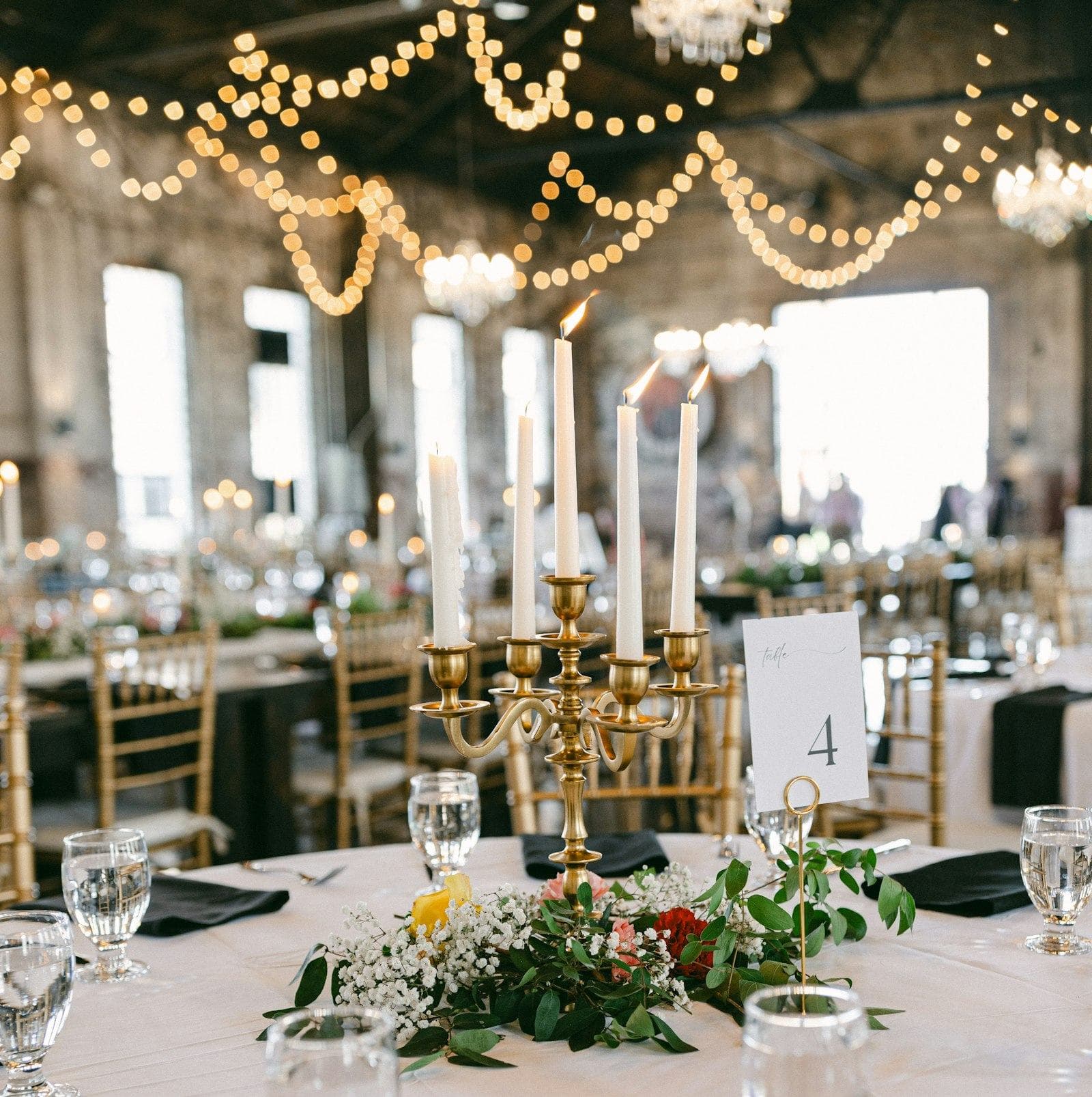A table number card beside a candelabra on a round table